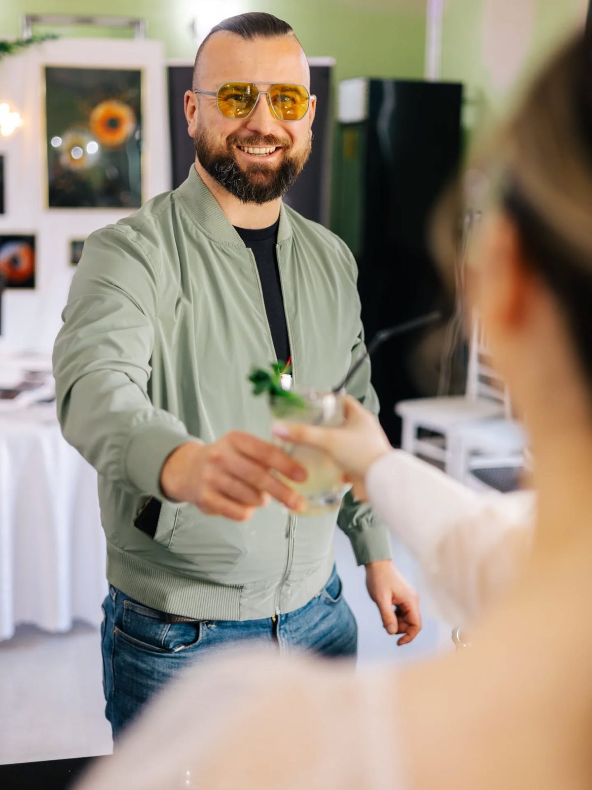 Egy vendég mosolyogva veszi át koktélját a BÁRHOLBAR pultjánál